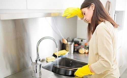 Женщина моет посуду